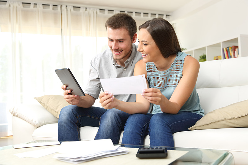 A couple on the couch managing their bills